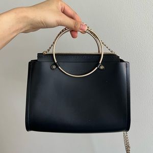 Future Glory Black Purse with hoop handles, zip, and chain